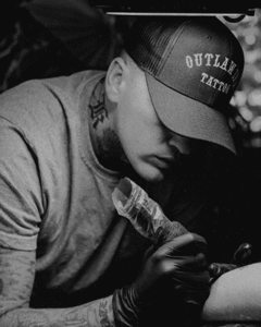 Tattoo artist working on client