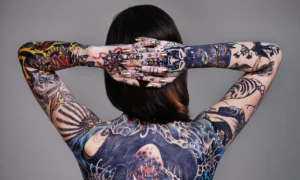 Tattooed arms crossed behind head