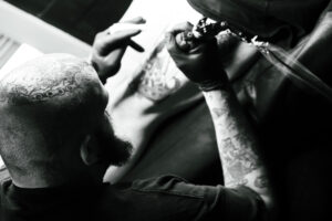 Tattoo artist working on client in Curly's studio